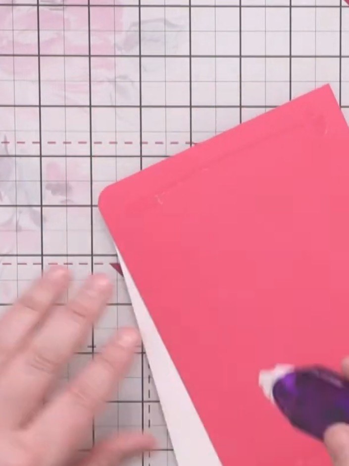 Step 7: Use a tape runner to apply adhesive to the back of the pink embossed panel. Position and adhere the panel onto