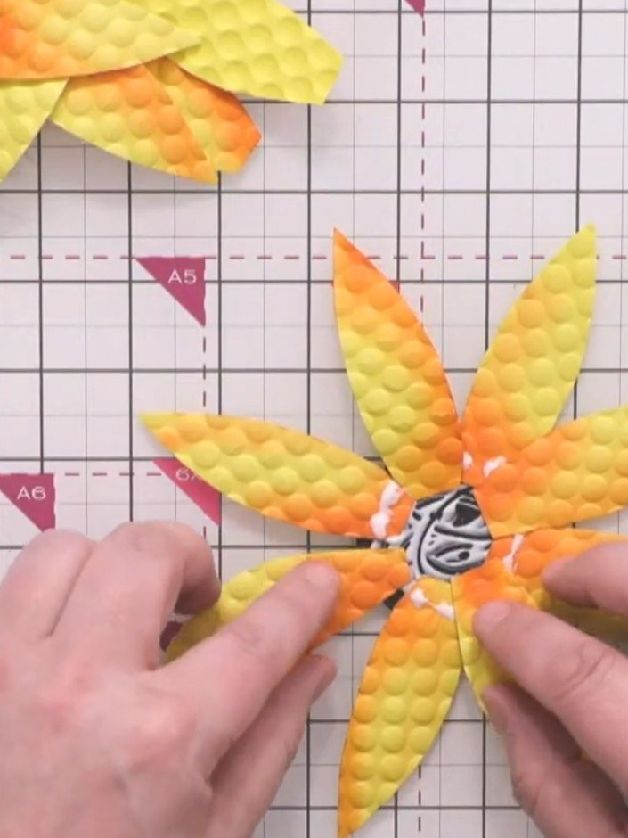 Step 9: Add a second layer of four petals between the first layer, positioning them in the gaps to create a fuller sun