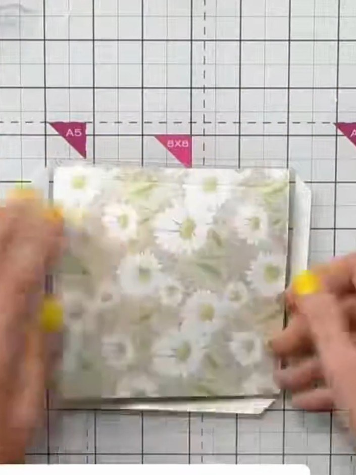 Step 7: Cover the back of the card with patterned paper featuring the daisy design to hide the hinge mechanism and com