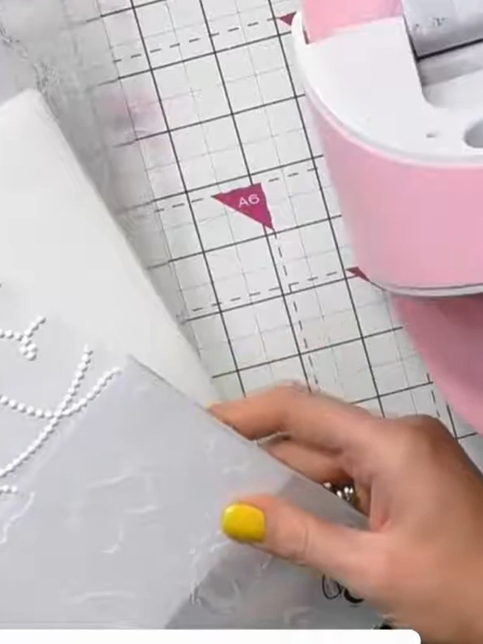 Step 4: Place the card with the embossed dripping hearts design onto the cutting mat and run it through the die-cuttin