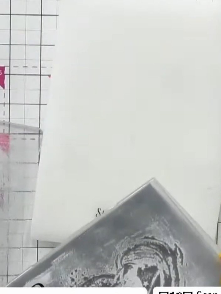 Step 4: Coloca la cartulina negra sobre la carpeta de embossing entintada, acomodándola con cuidado sobre el diseño.