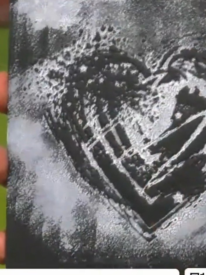 Step 6: Remove the black cardstock from the die-cutting machine and examine the embossed heart design. The 3D embossin