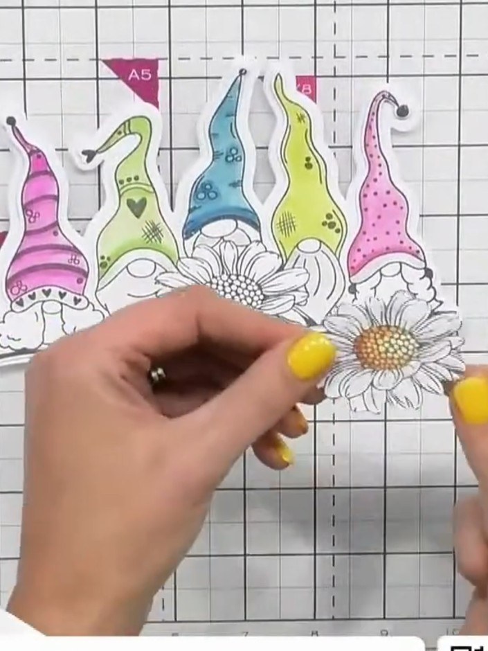 Step 9: Position the flower element on the front of the card, placing it centrally at the bottom between the coloured 