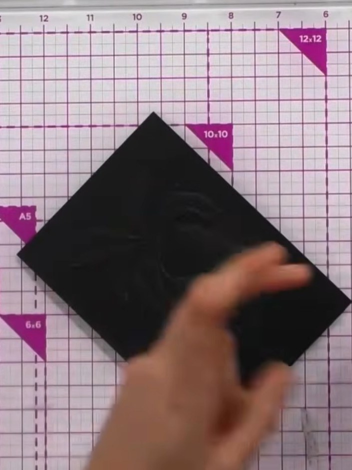 Step 4: Use your thumb or finger to rub the gold wax into the embossed details on the black card, working it into both