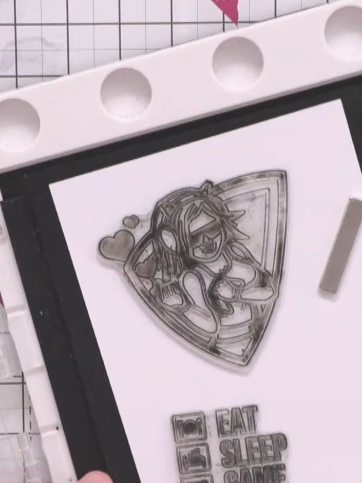 Step 10: Position the large Crash character stamp and the 'Eat Sleep Game Repeat' sentiment stamp onto white cardstock.