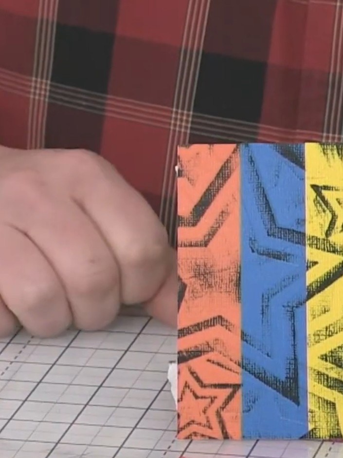 Step 7: Lightly brush black ink across the embossed stars on the coloured strips using a flat glass mat. This adds dep