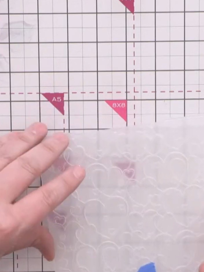 Step 1: Place the textured cardstock into the Love Hearts embossing folder, ensuring the paper is positioned within th