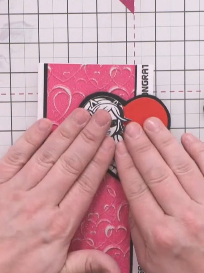 Step 15: Attach the large red heart with the character stamp to the card front using foam pads, positioning it off-cent