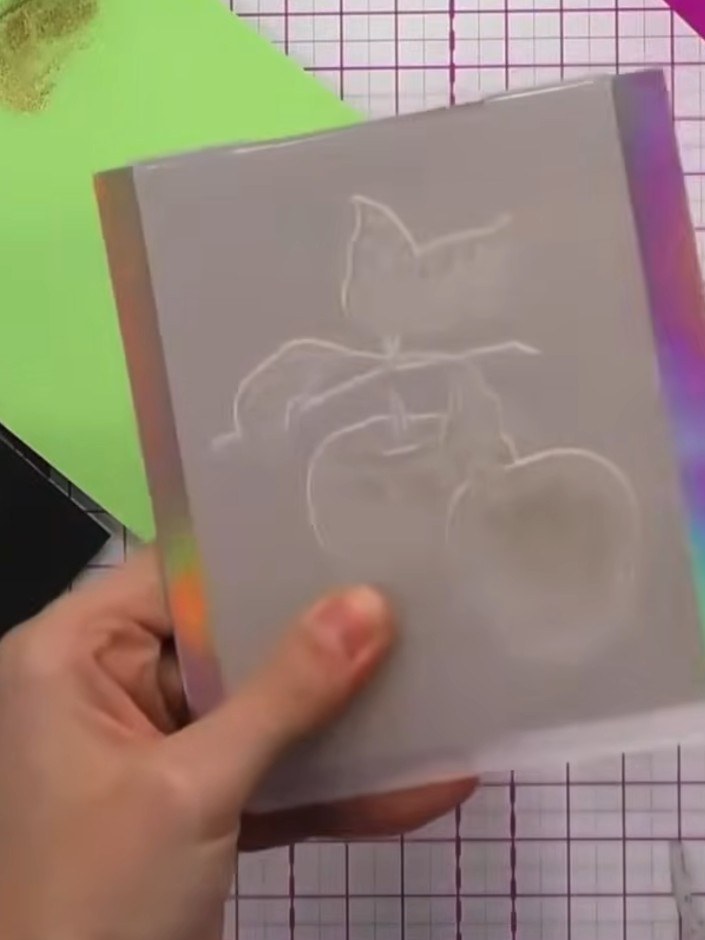 Step 1: Place your white card stock inside the embossing folder with the pear design, ensuring it is positioned correc
