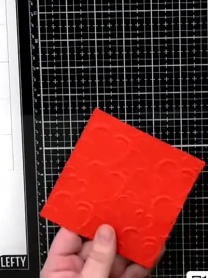 Step 1: Cut a piece of red card to size. Run it through the love hearts embossing folder to create the embossed patter