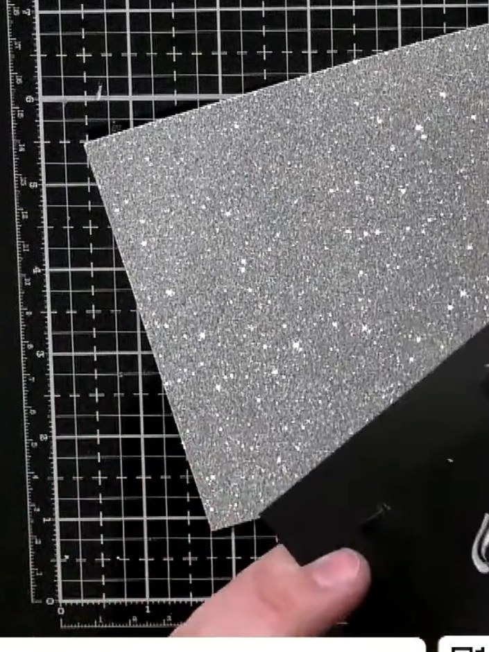 Step 4: Mount the embossed red panel onto a piece of black card using double-sided tape. Position the silver glitter c