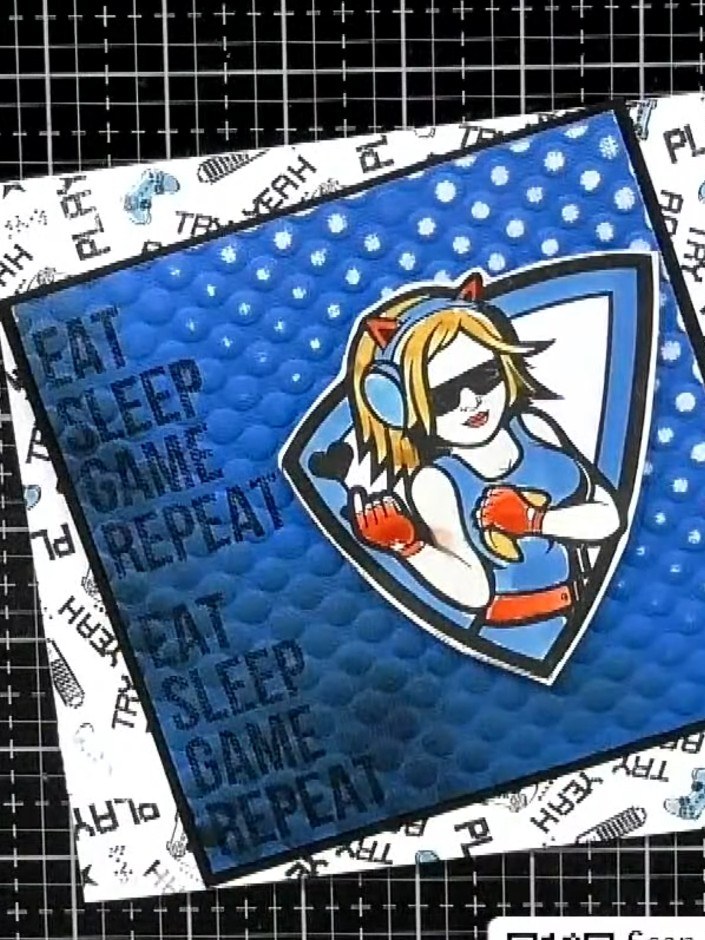 Step 10: Stamp the gaming-themed sentiment around the edges of a white card blank. Position the stamped card blank behi