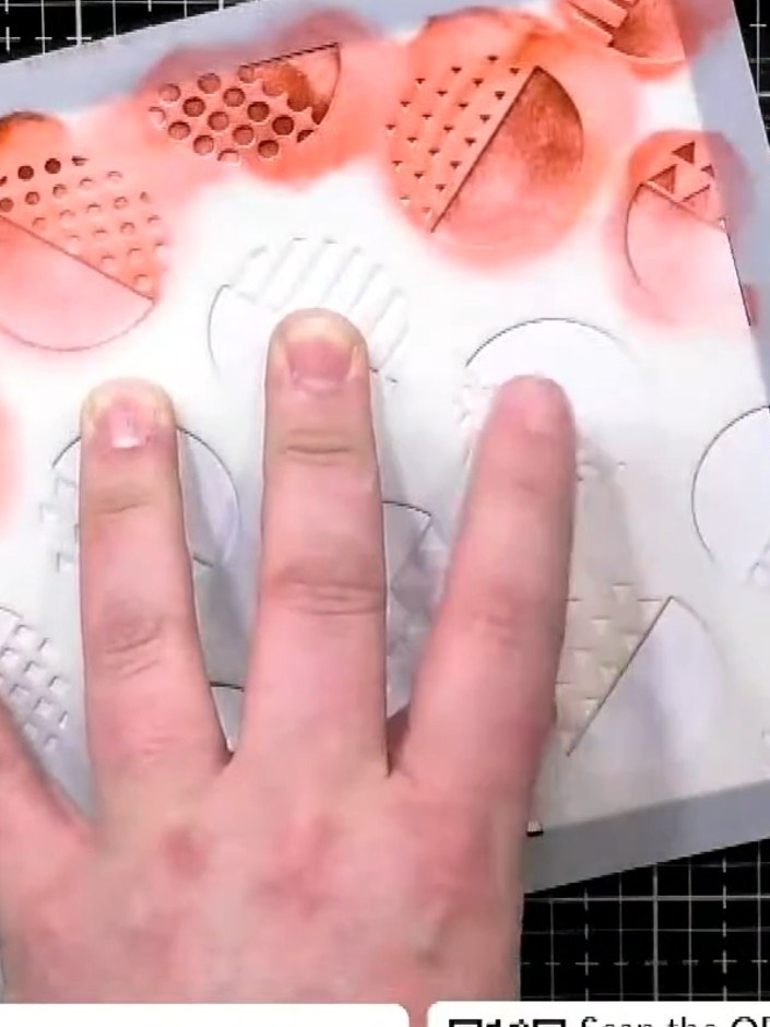 Step 2: Using a detail brush, pick up red ink and apply it lightly around the edges of the stencil shapes. Start with 