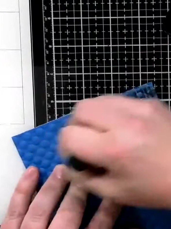 Step 7: Apply black ink to the bottom corner of the embossed card using a sponge applicator to create a grungy, distre