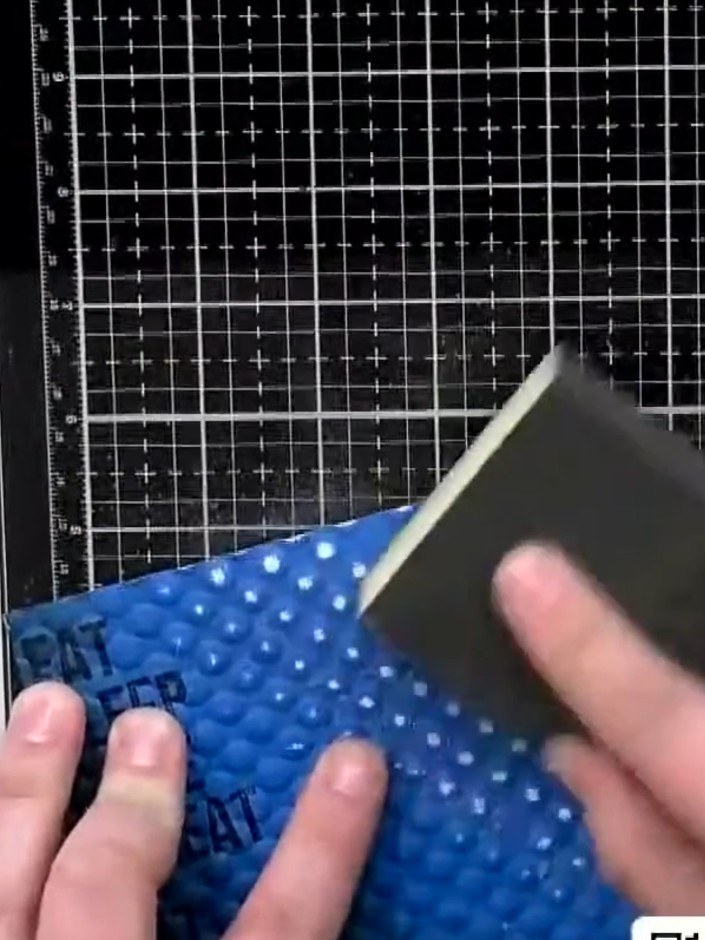 Step 9: Monta el panel con relieve sobre la tarjeta base azul decorada con esténcil usando adhesivo.