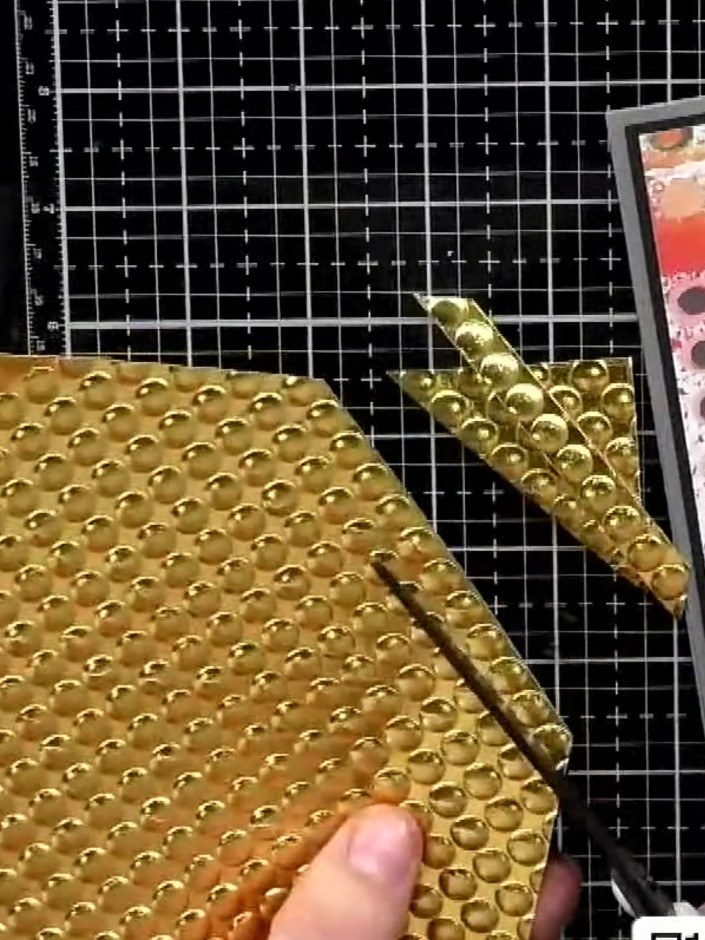 Step 2: Cut the gold embossed paper along the diagonal to create strips of varying widths. Use scissors or a craft kni
