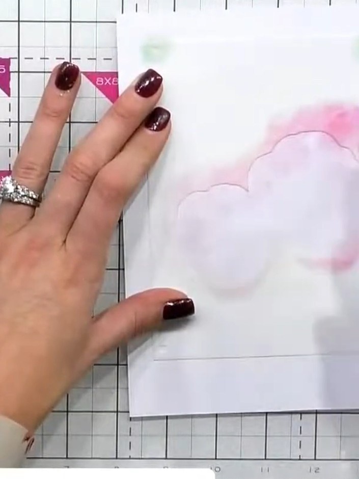 Step 2: Apply pink ink through the stencil onto the card, pressing lightly with the ink pad to create the base petal c