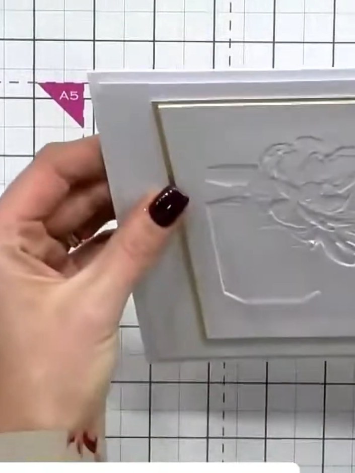 Step 1: Place your white cardstock into the 3D embossing folder, ensuring the perfume bottle and flower design is prop