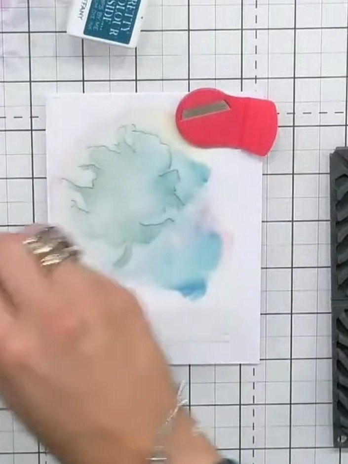 Step 2: Apply teal ink through the first stencil using a sponge or blending tool. Work from light to medium tones, bui