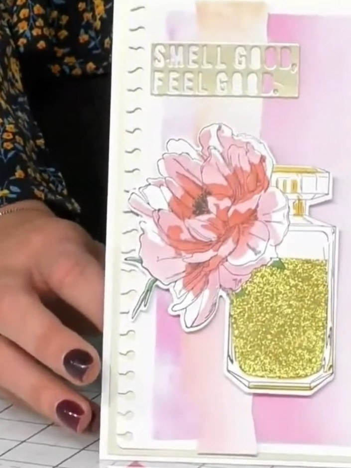 Step 9: Add a sentiment to the top of the card. The 'SMELL GOOD, FEEL GOOD' sentiment in gold and pink completes the d