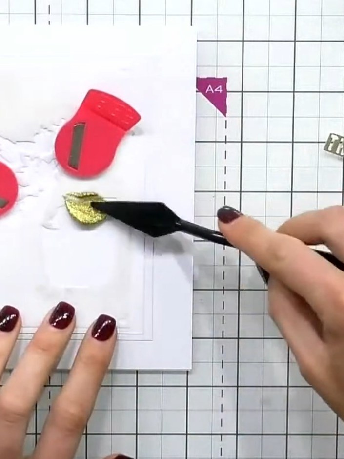 Step 2: Apply gold glitter paste over the embossed perfume bottle design using a palette knife or spatula. Smooth the 