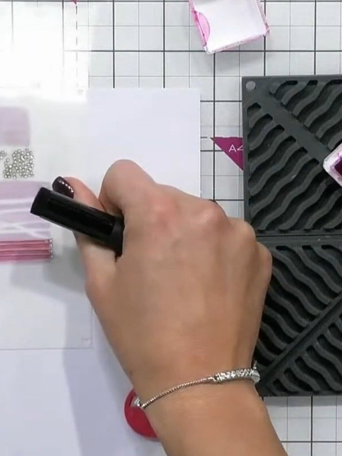 Step 5: Position stencil number three over your card. Using the pink ink pad and blending tool, add horizontal lines a