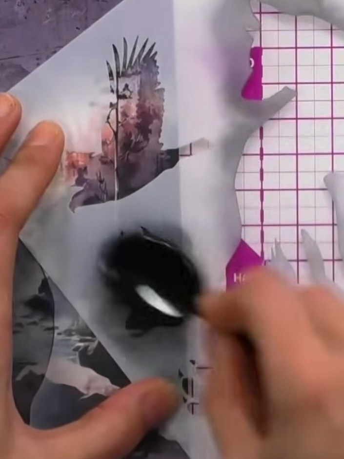 Step 6: Using a stamp or mask, add subtle paw print details in black ink around the wolf silhouette to enhance the com
