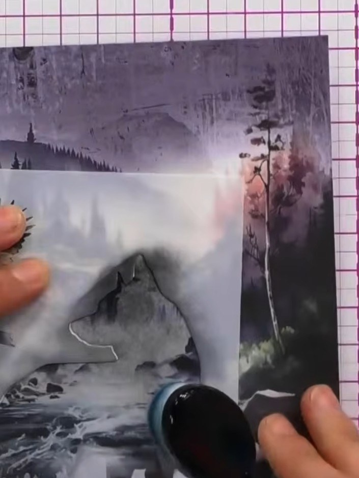Step 7: Layer a sheet of vellum with tree line details across the front of the card to add depth and create a misty, a