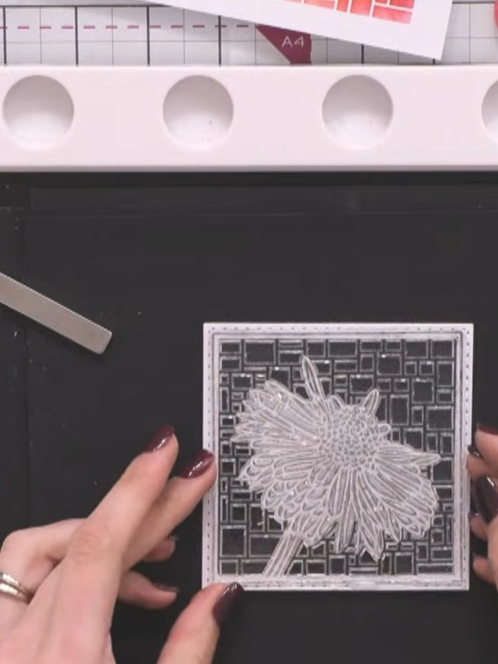 Step 10: Place your die-cut daisy piece back into the die space on the black card. Hold it in position with a magnet, t