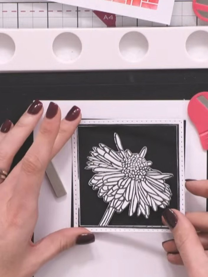 Step 11: Carefully remove the stamped flower element from the centre of the white frame using a craft knife or scissors
