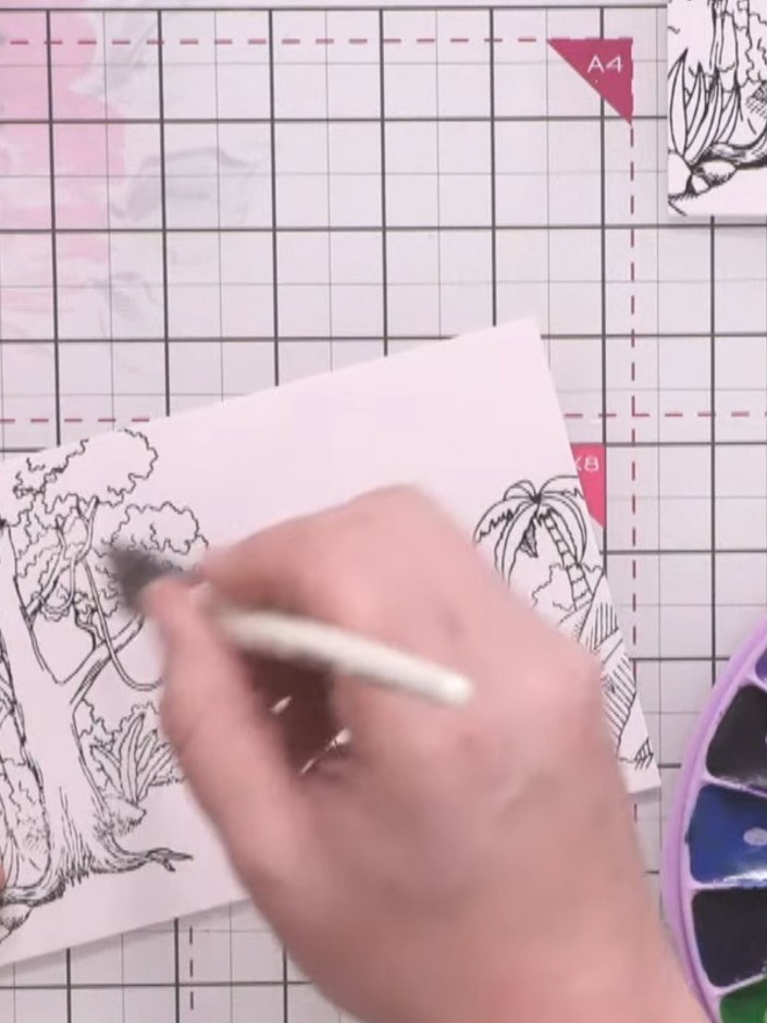 Step 5: Apply a water wash to the dinosaur background stamp image. Using watercolours from your palette, paint the bac