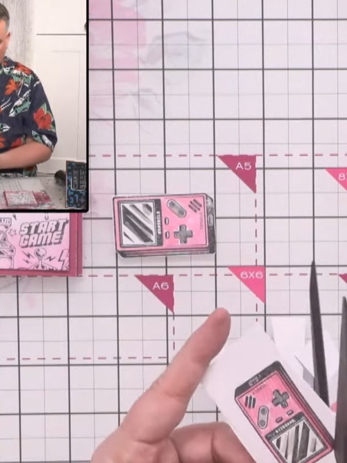 Step 13: Cut out the three game console images that you stamped earlier. Apply adhesive to the back of each console and