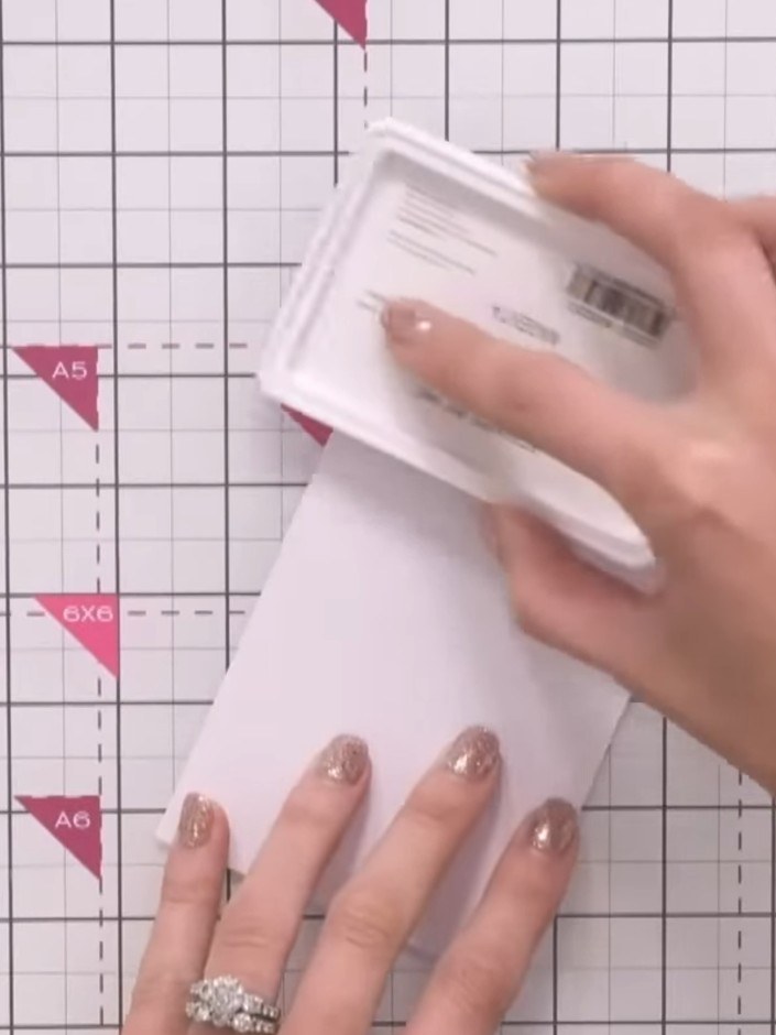 Step 1: Empieza con una cartulina blanca tamaño A5 como base. Colócala sobre tu tapete de manualidades, lista para sellar.