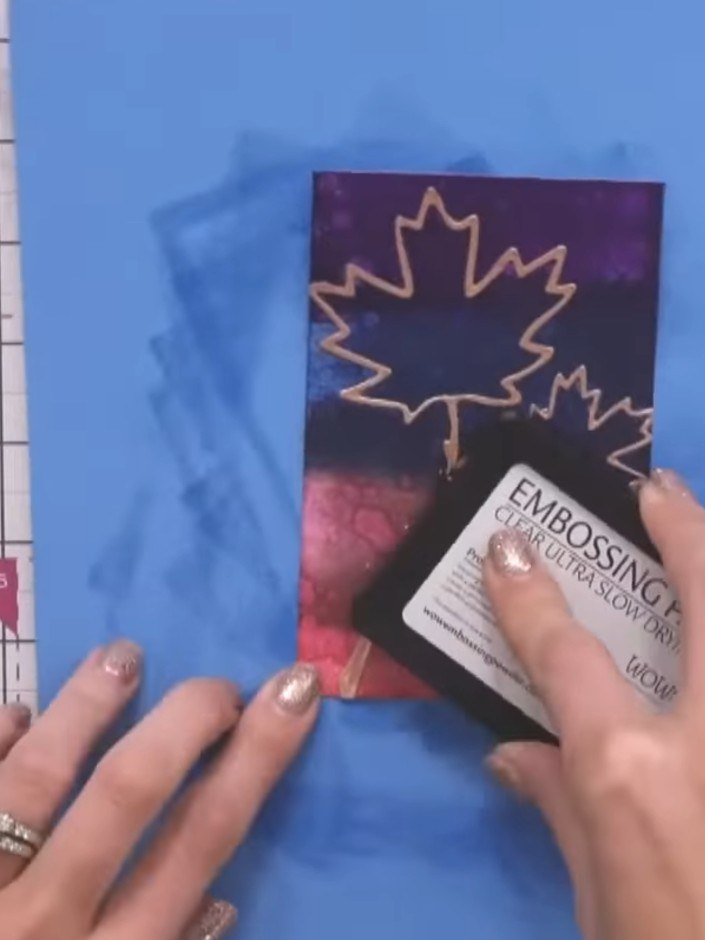 Step 10: Heat-set the embossing powder with a heat gun, moving it evenly over the maple leaf design until the powder is