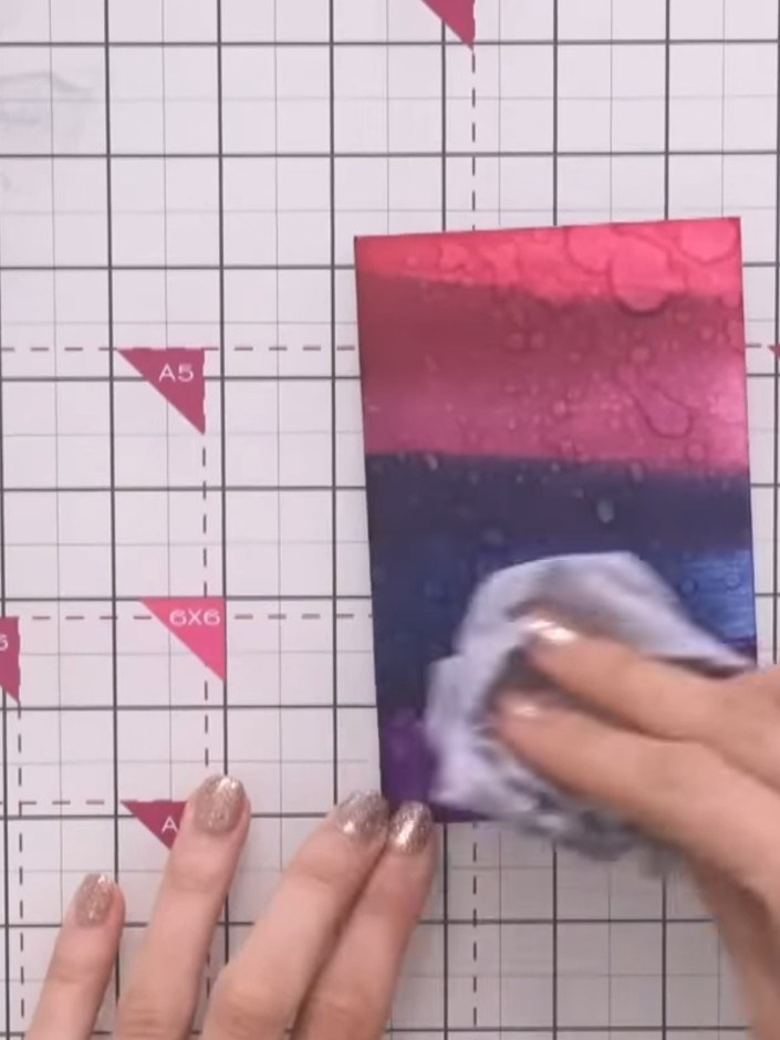 Step 6: Spray water from a spray bottle onto the inked background to create texture and water-resistant effects. The w
