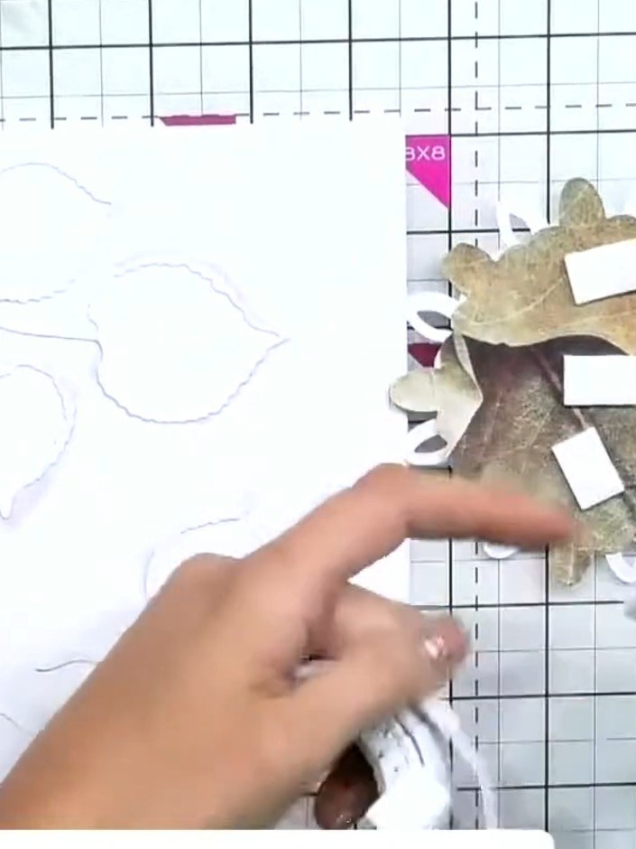 Step 8: Add foam pads to the back of your layered leaf aperture piece. Position it centrally on your white card base a