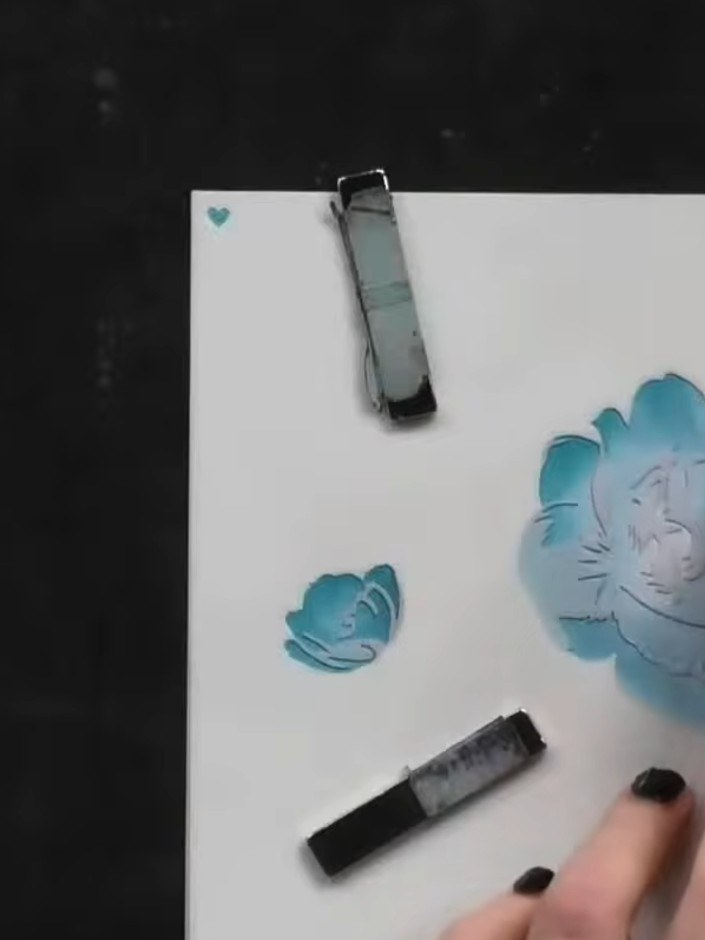 Step 4: Apply a darker shade of blue ink over the same rose stencil, focusing on building depth and dimension. Blend t