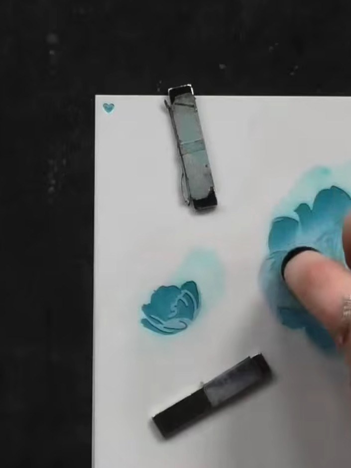 Step 5: Position the third stencil layer over your card. Apply teal ink through the stencil using a blending tool to c