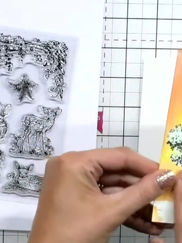 Step 6: Select a small animal stamp from your woodland stamp set and stamp it in black ink at the base of your tree to