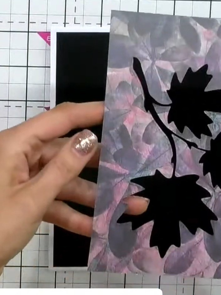 Step 5: Position the stacked black maple leaf embellishment inside the aperture of the patterned die-cut panel, ensuri
