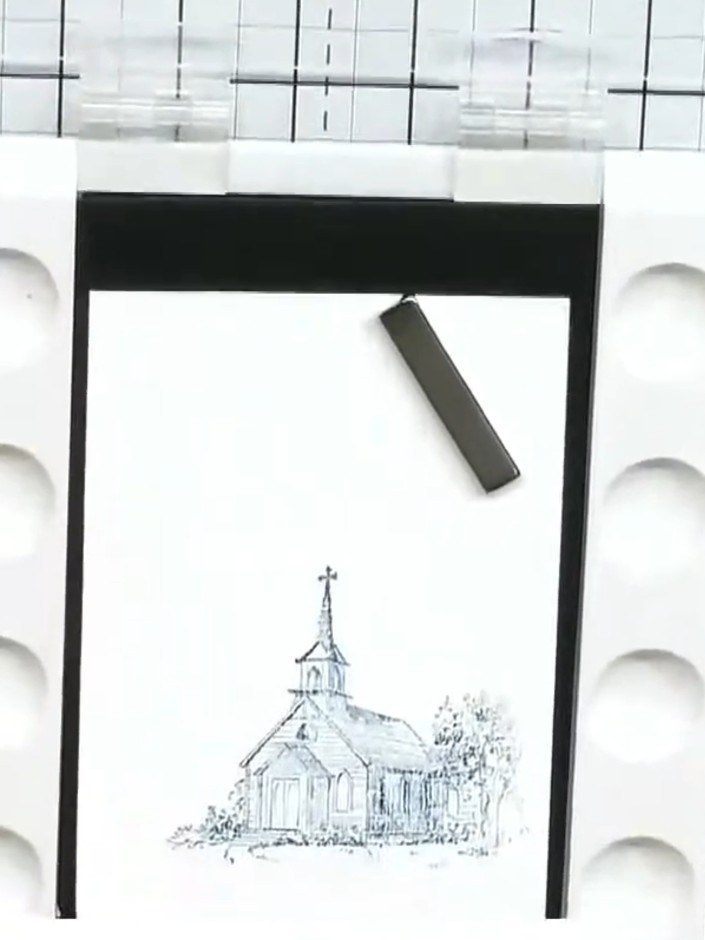 Step 2: Con un pincel húmedo, humedece la zona alrededor de la iglesia estampada para prepararla para la aguada de acuarela.
