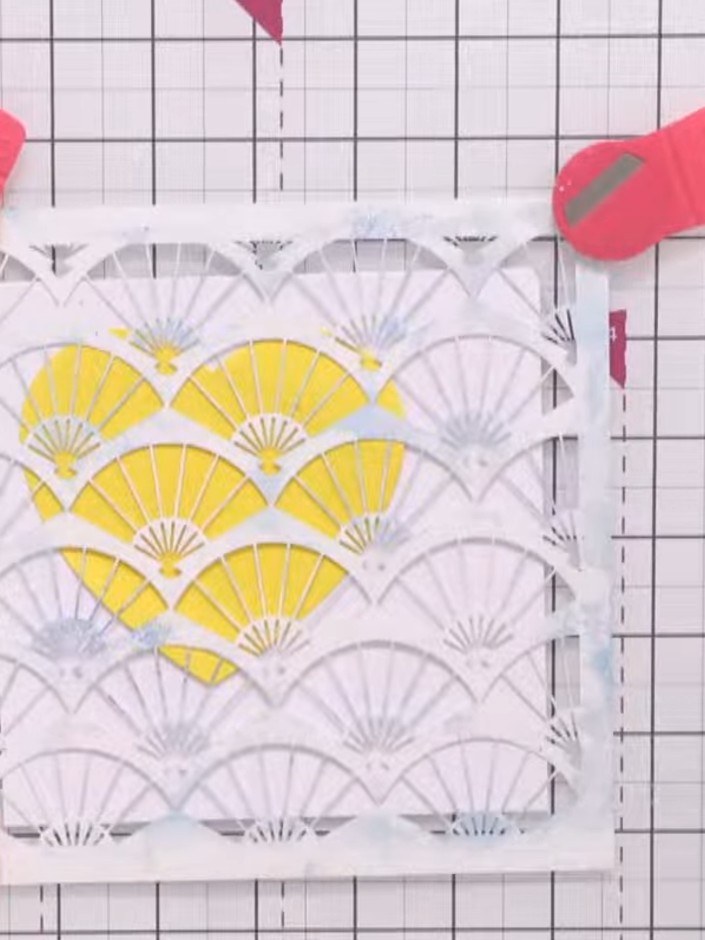 Step 4: Position the oriental fan stencil on your card and secure it in place with magnets at the corners to prevent i