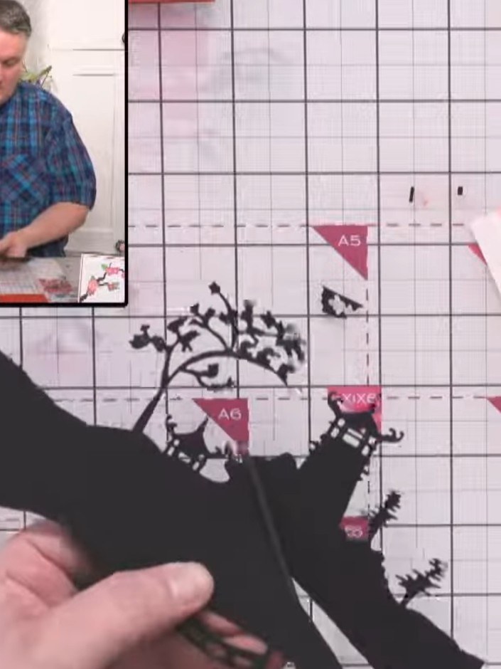 Step 10: Cut sections of the black landscape die-cut to fit inside each heart opening on the card front. Position the l