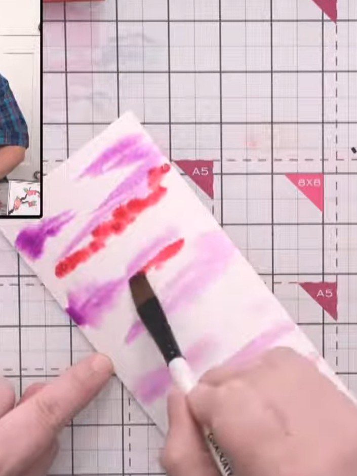 Step 13: Add bright red watercolour underneath the purple stripes, allowing the colours to blend and bleed together nat