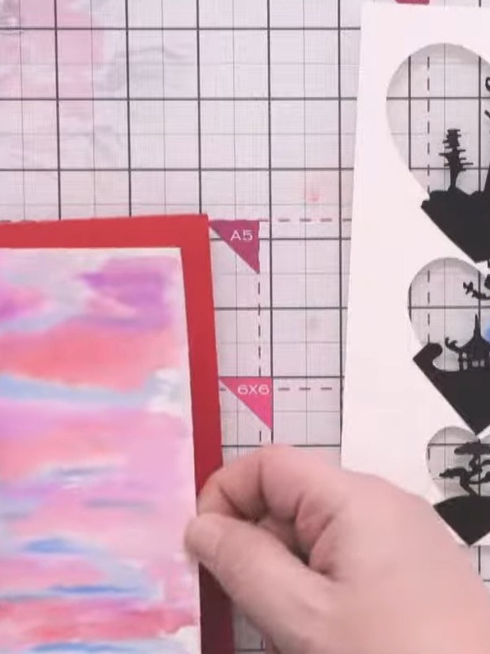 Step 16: Apply tape runner adhesive to the back of the watercoloured panel. Position and adhere it to the inside back o
