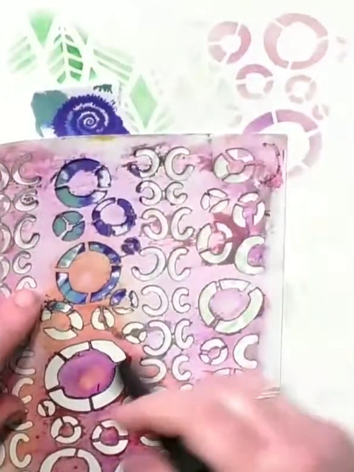 Step 5: Place the Broken Circles stencil over your collage page and stamp through it using the eye stamp and your chos
