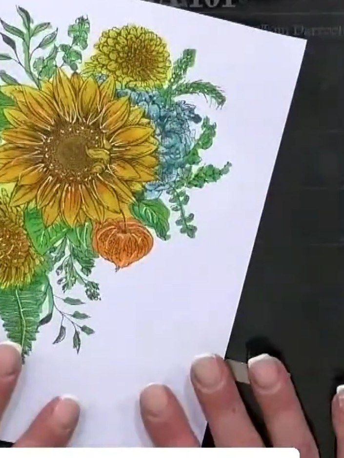 Step 3: Colour the sunflower using watercolour or markers, blending yellows and oranges on the petals for depth. Add g