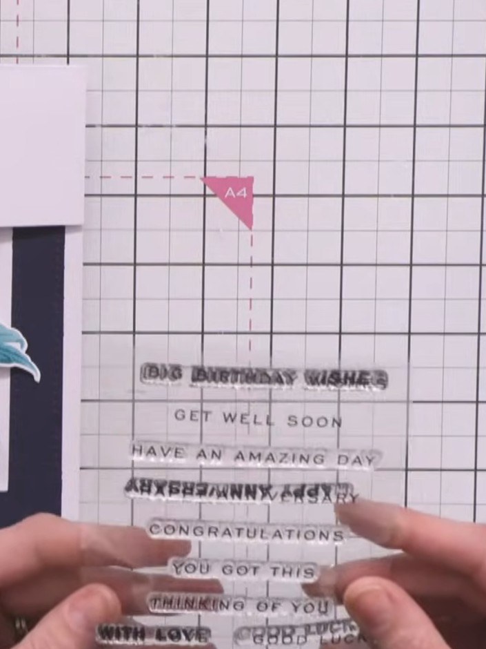 Step 8: Stamp a sentiment such as 'Thinking of you' onto a small strip of white card stock using navy ink. Trim the st
