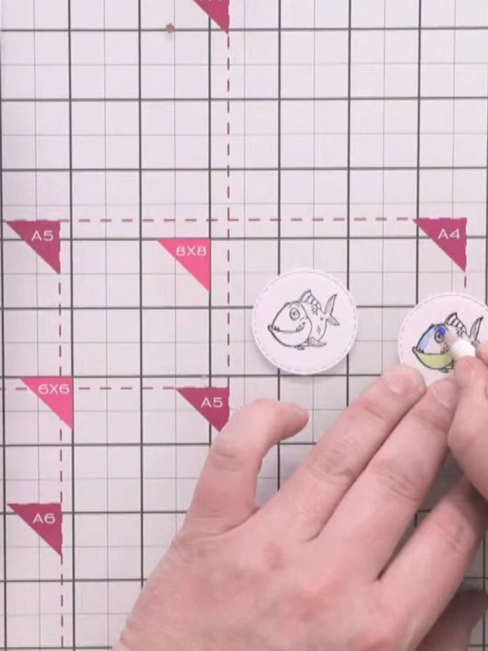Step 10: Colour the fish stamps with oil pencils using complementary colours such as green, blue and yellow. Blend the 