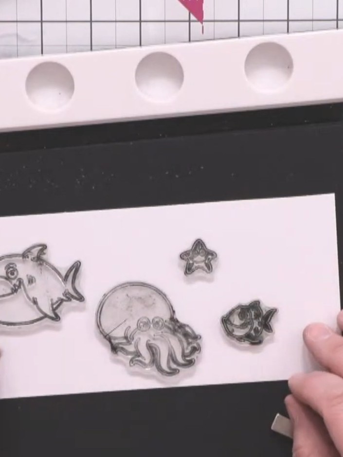 Step 10: Stamp the underwater character designs (shark, octopus, starfish, and fish) onto white card using midnight bla